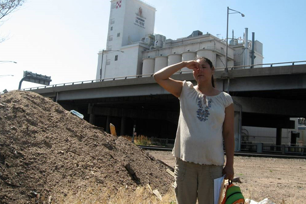 Woman standing in front of processing plant.