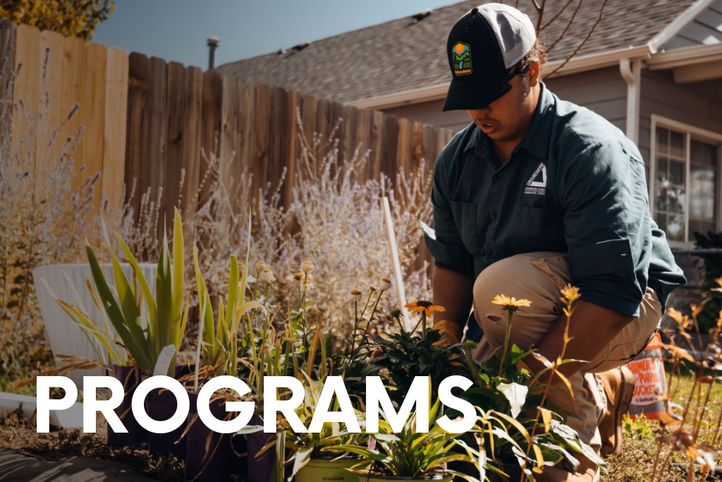 Programs. Image of a person in Groundwork Denver shirt planting flowers.