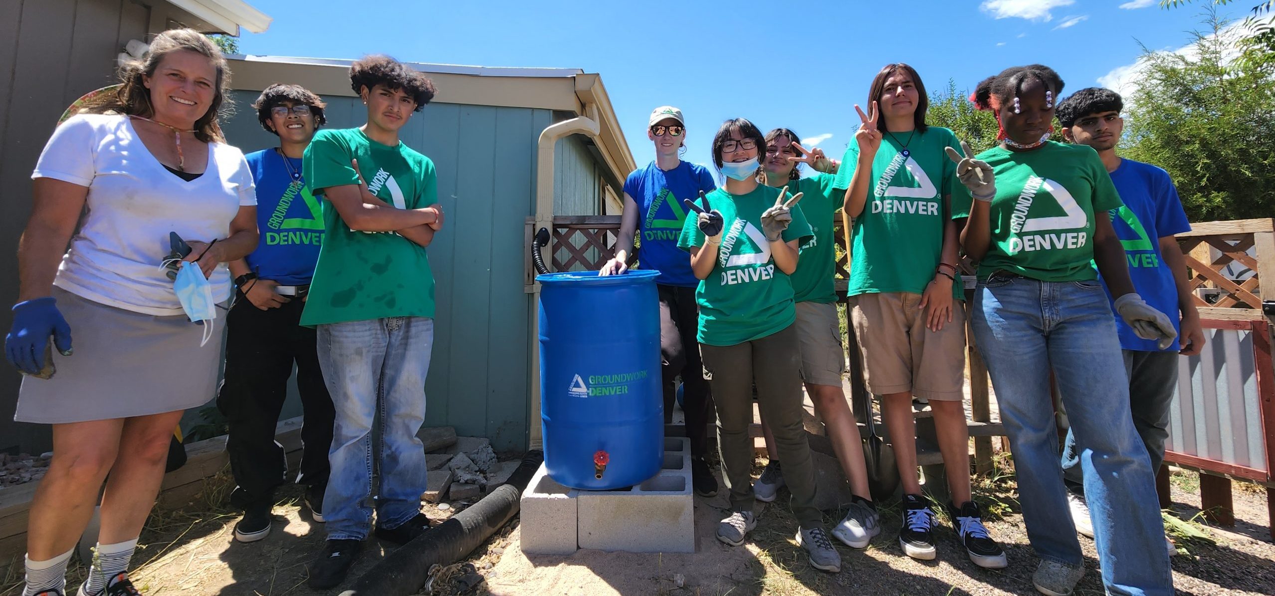Groundwork Denver youth team group photo around a recently installed rain barrel