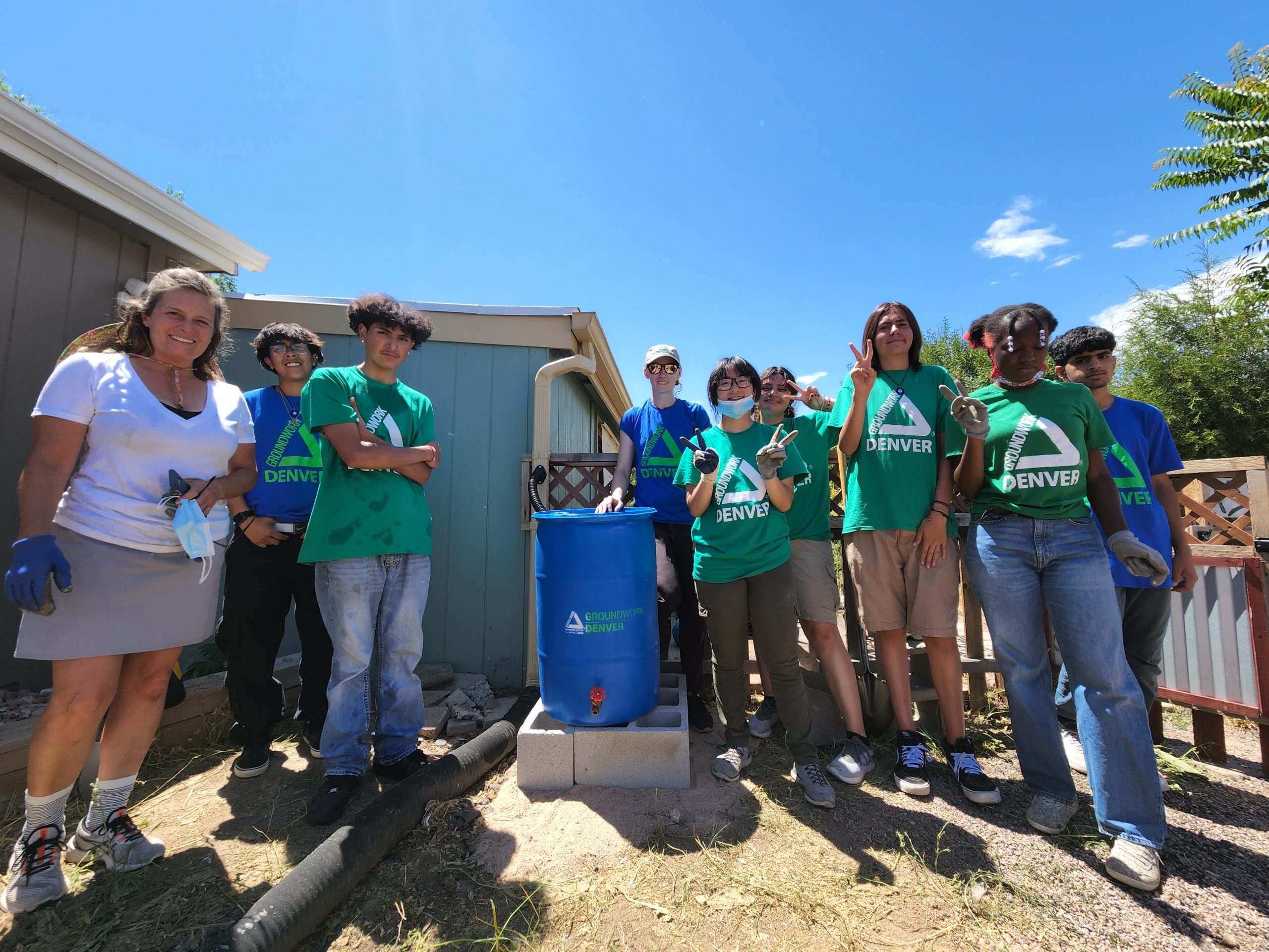 Groundwork Denver youth team group photo around a recently installed rain barrel